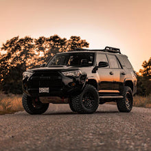 Load image into Gallery viewer, A black Toyota 4Runner is parked on a dirt road, showcasing its increased ground clearance with an OME 3 inch Lift Kit for 4Runner (10-23) and Old Man Emu Nitrocharger shocks.