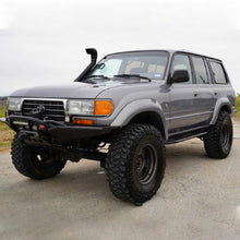 Load image into Gallery viewer, An Old Man Emu-equipped gray Toyota Land Cruiser with the OME 2 inch Lift Kit for LandCruiser 80 &amp; 105 Series (90-07) is parked in a parking lot.