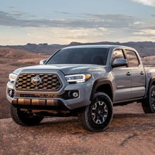 Load image into Gallery viewer, The 2020 Toyota Tacoma, equipped with the Old Man Emu OME 2.5 inch Essentials Lift Kit for Tacoma (16-23), is parked in a desert. With enhanced suspension articulation and impressive ground clearance, this Toyota Tacoma is ready for any.