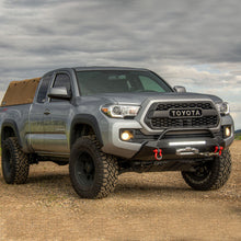 Load image into Gallery viewer, The 2019 Toyota Tacoma, equipped with an enhanced suspension articulation thanks to the OME 2.5 inch Essentials Lift Kit for Tacoma (16-23) by Old Man Emu, confidently rests on a dirt road, showcasing its impressive ground clearance.