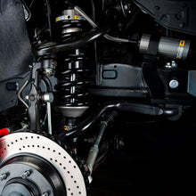 Load image into Gallery viewer, A close up of a Land Rover Defender 110&#39;s suspension system featuring an Old Man Emu shock absorber body with a remote reservoir, specifically the OME BP-51 Front Shock Absorber BP5160045.