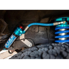 Load image into Gallery viewer, A blue King Shocks shock is attached to the underside of a vehicle, enhancing its off-road performance with advanced valving technology.