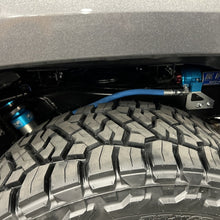 Load image into Gallery viewer, An off-road performance jeep wrangler with King Shocks and advanced valving technology, with a blue hose attached to it.