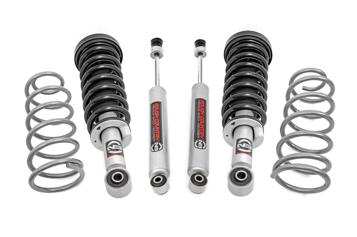 Suspension kit with four coil springs and four shock absorbers arranged on a white background