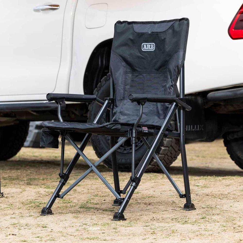 ARB Base Camp Chair 10500151 with heavy-duty steel frame, padded armrests, swivel cup holder, and rear mesh storage pocket