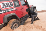 ARB TRED Pro Blue Recovery Boards TREDPROBU deployed by man freeing red 4-door Jeep Wrangler stuck in sandy terrain