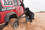 ARB TRED Pro Blue Recovery Boards TREDPROBU deployed by man extricating red 4-door Jeep Wrangler stuck in sandy desert terrain