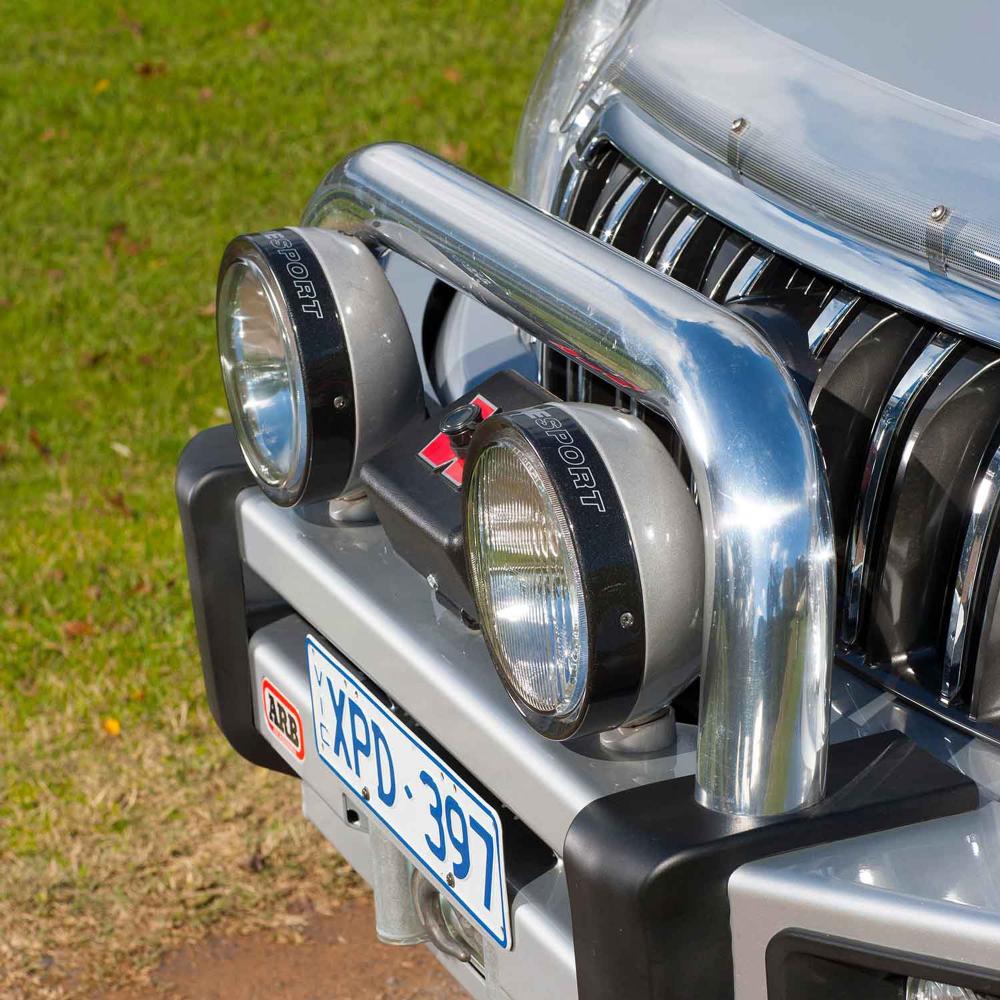 ARB Sahara Tube 5100050 for Land Cruiser 100 Series polished steel center tube with molded protection buffers and mounted auxiliary lights
