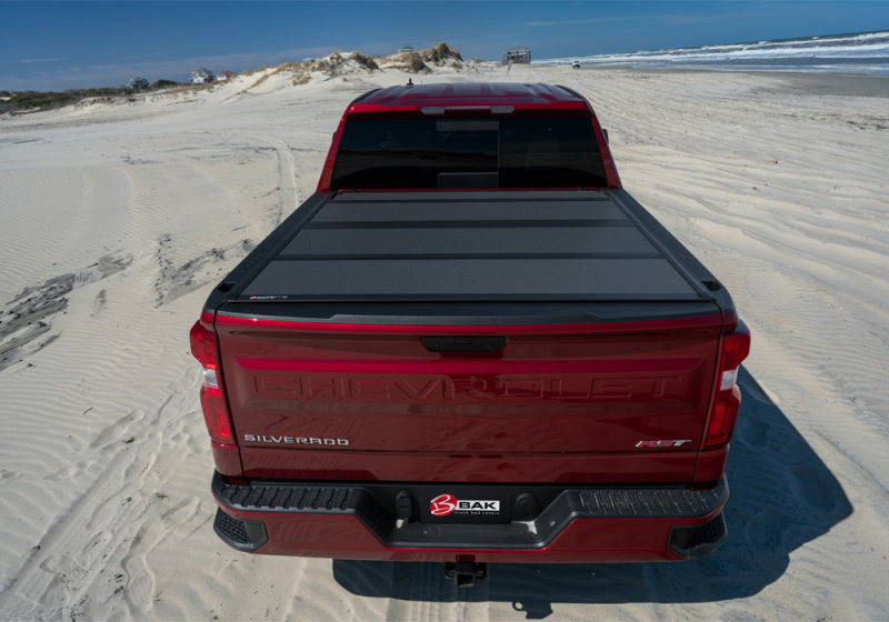 BAK BAKFlip MX4 Hard Folding Tonneau Cover 448446 for Toyota Tacoma (24-ON) on red truck bed with heavy-duty black panels