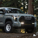 Baja Designs 2022+ Toyota Tundra S2 SAE OEM Fog Light Replacement Kit - Clear dual LED fog lights installed on rugged front bumper