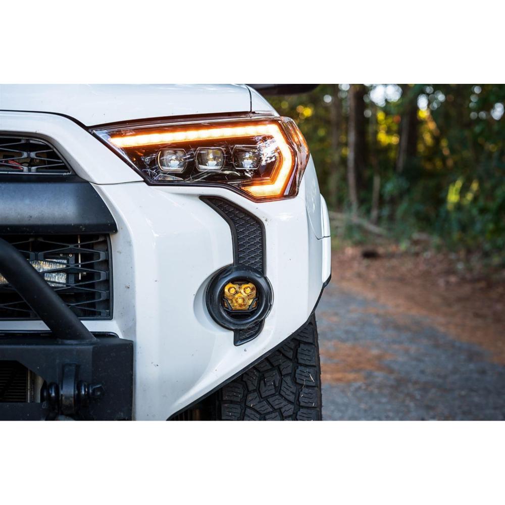 Morimoto 4Banger NCS LED Fog Lights Kit (Yellow SAE Wide Beam) installed on 4th gen Toyota Tacoma fog light housing with rugged tires