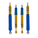 Bilstein yellow and blue shock absorbers with protective boots and mounting ends, shown as a four piece set