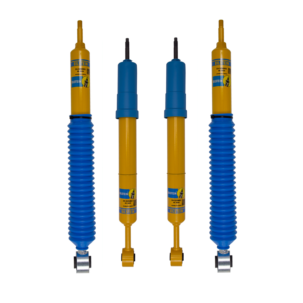 Bilstein yellow and blue shock absorbers with protective boots and mounting ends, shown as a four piece set