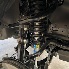 Load image into Gallery viewer, The rear suspension of a vehicle is shown, featuring the Bilstein B8 5100 shock absorbers and Bilstein B8 5100 2 inch 4Runner (10-ON) Lift Kit w/ OME Springs - Front Shock Assembly for enhanced off-road performance.