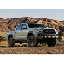 Load image into Gallery viewer, The 2019 Toyota Tacoma is equipped with a Bilstein B8 5100 2.5 inch Tacoma (16-23) Lift Kit w/ OME Springs - Front Shocks Assembly, including Old Man Emu Springs, and is parked on a dirt road.