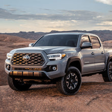 Load image into Gallery viewer, The 2020 Toyota Tacoma, equipped with the Bilstein B8 6112/5100 0-2 inch Tacoma (16-23) Lift Kit w/ OME Leaf Springs - Front Shocks Assembly upgrade, is shown in the desert during an off-road adventure.