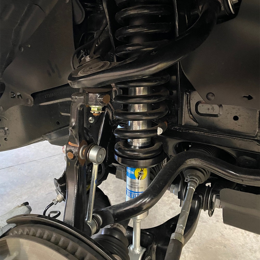 The rear suspension of a vehicle is shown, featuring the Bilstein B8 6112/5160 2 inch 4Runner (10-ON) Lift Kit w/ OME Springs for optimal off-road adventures.