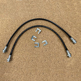 A pair of durable Mudify Extended Rear Brake Lines for Toyota 4Runner 2003-ON, FJ Cruiser 2007-ON, Lexus GX460 & GX470 2003-ON, designed for brake lines, are positioned on a wooden surface. The hoses are capable of withstanding axle movements with ease.
