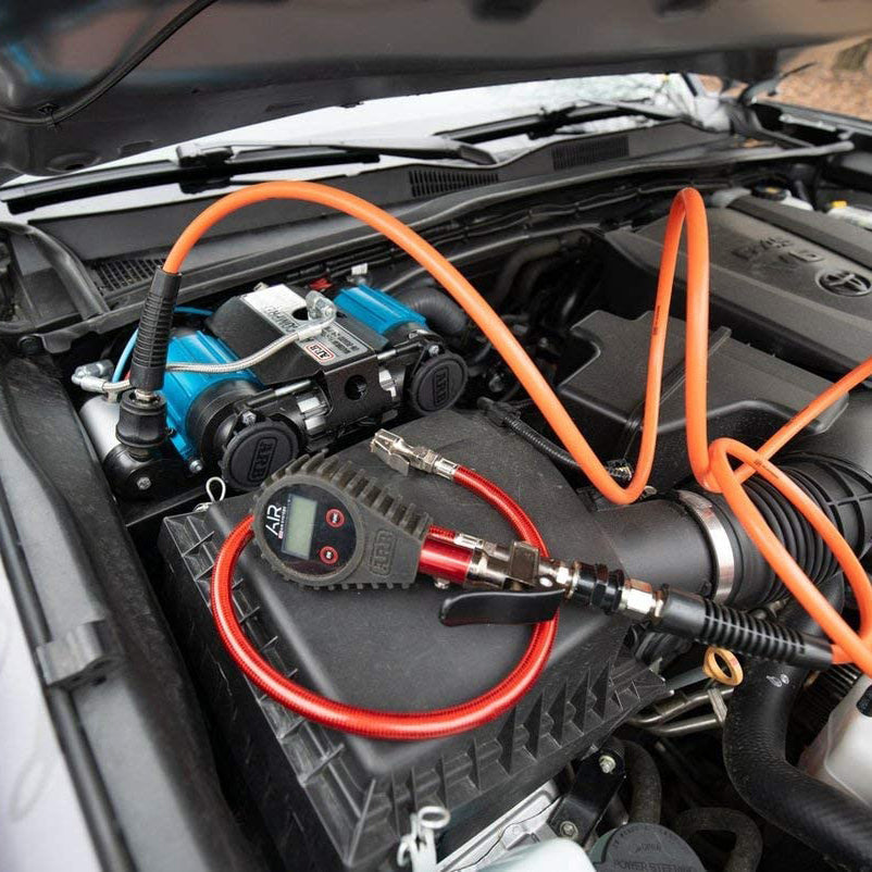 ARB 12 Volts On-Board Twin High Performance Air Compressor with Manifold Kit CKMTA12KIT installed in Toyota engine bay with orange air lines