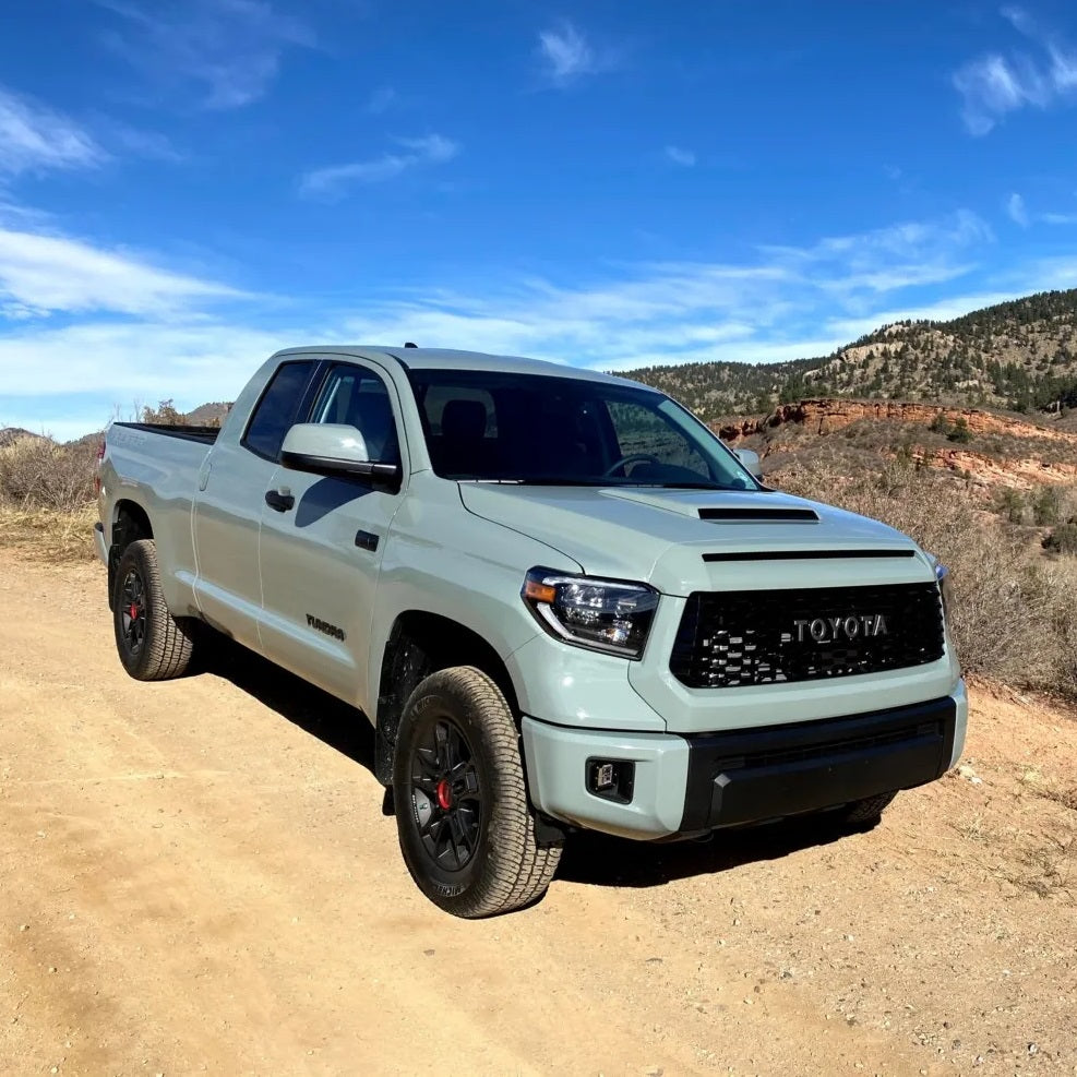 The 2019 Toyota Tundra, equipped with the KING 2 - 3 inch Lift Kit for Tundra (07-21) by King Shocks for enhanced off-road performance, is parked on a dirt road, showcasing its stability.