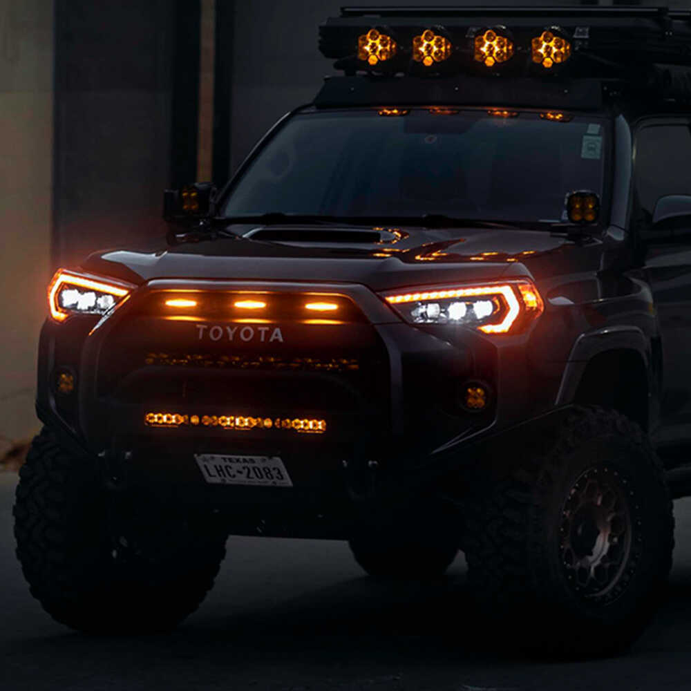A black Toyota 4Runner with Morimoto XB Led Headlights for Toyota 4Runner (2014-2023) is parked at night.
