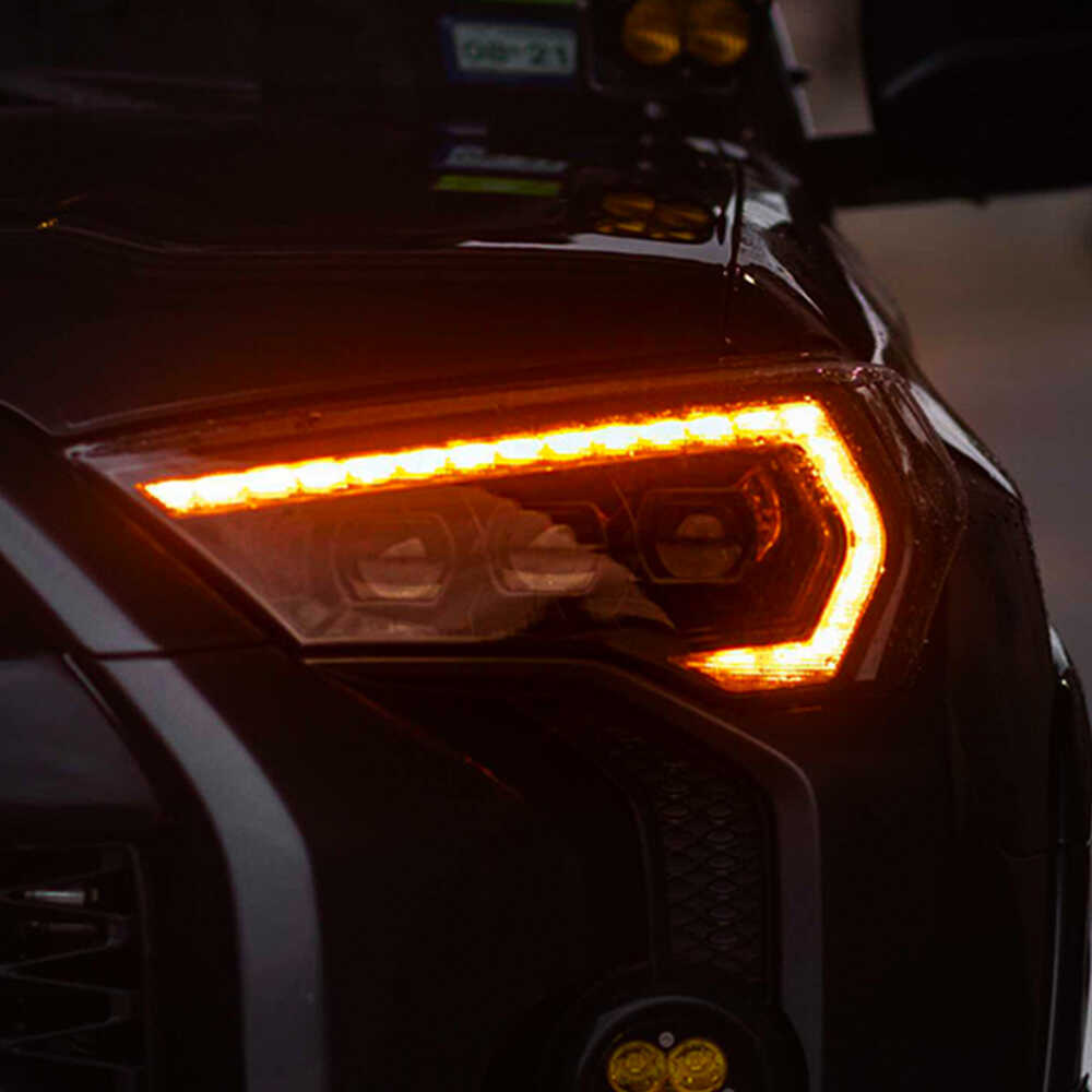 A close up of the headlights of a black SUV featuring Morimoto XB Led Headlights for Toyota 4Runner (2014-2023).