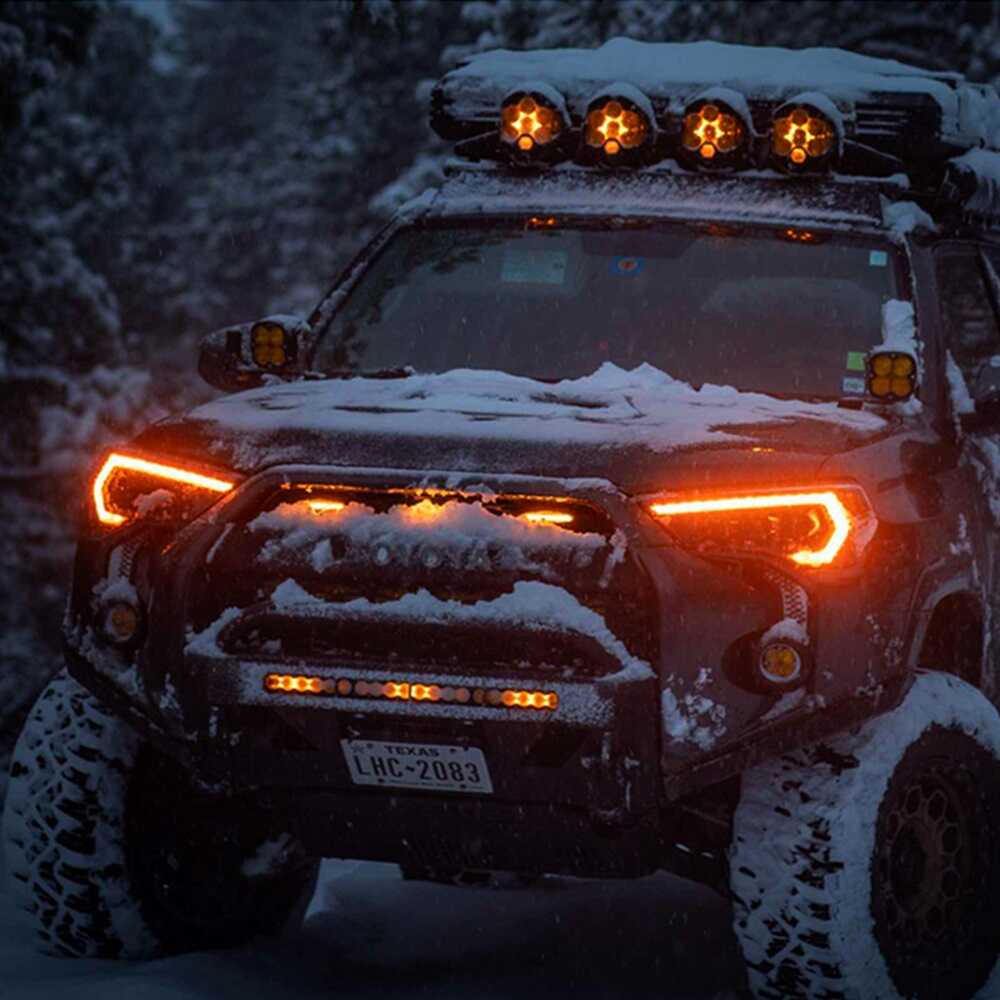 A Toyota Tacoma with Morimoto XB Led Headlights for Toyota 4Runner (2014-2023) is parked in the snow.