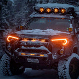 A Toyota Tacoma with Morimoto XB Led Headlights for Toyota 4Runner (2014-2023) is parked in the snow.