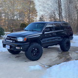 An Old Man Emu 2 inch Lift Kit for 4Runner (96-02) black with increased ground clearance is parked in the snow.
