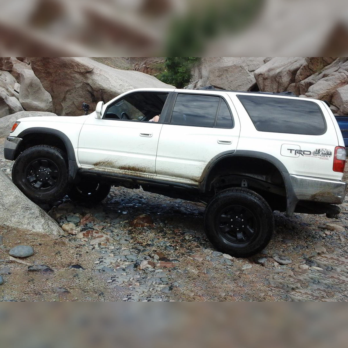 A white Old Man Emu 2 inch Lift Kit for 4Runner (96-02) is parked on a rock.