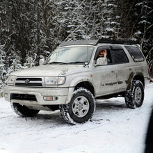 Load image into Gallery viewer, A silver Toyota 4Runner, equipped with an OME 2 inch Lift Kit for 4Runner (96-02) by Old Man Emu, confidently navigates through the snowy terrain with its increased ground clearance.