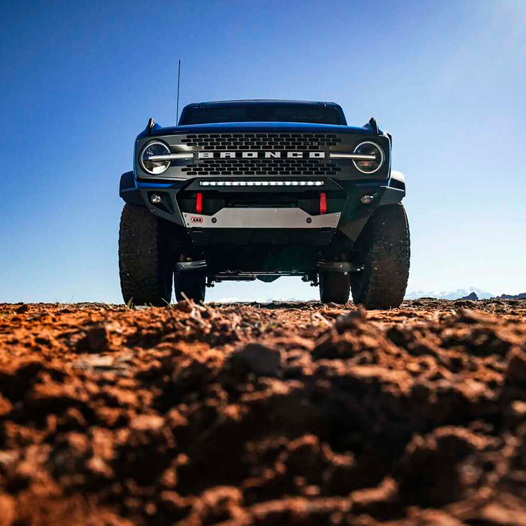A black Ford Bronco parked on a dirt road, featuring an enhanced ride quality with the Old Man Emu OME 3 inch Lift Kit for Bronco Black Diamond, Badlands (21-ON) suspension system and Nitrocharger shocks.