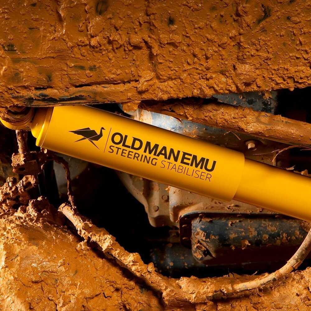 An elderly man excavating with a yellow OME 2 inch Lift Kit for Land Rover Defender 110 (85-17), ensuring optimal ground clearance with his suspension system using Old Man Emu's expertise.