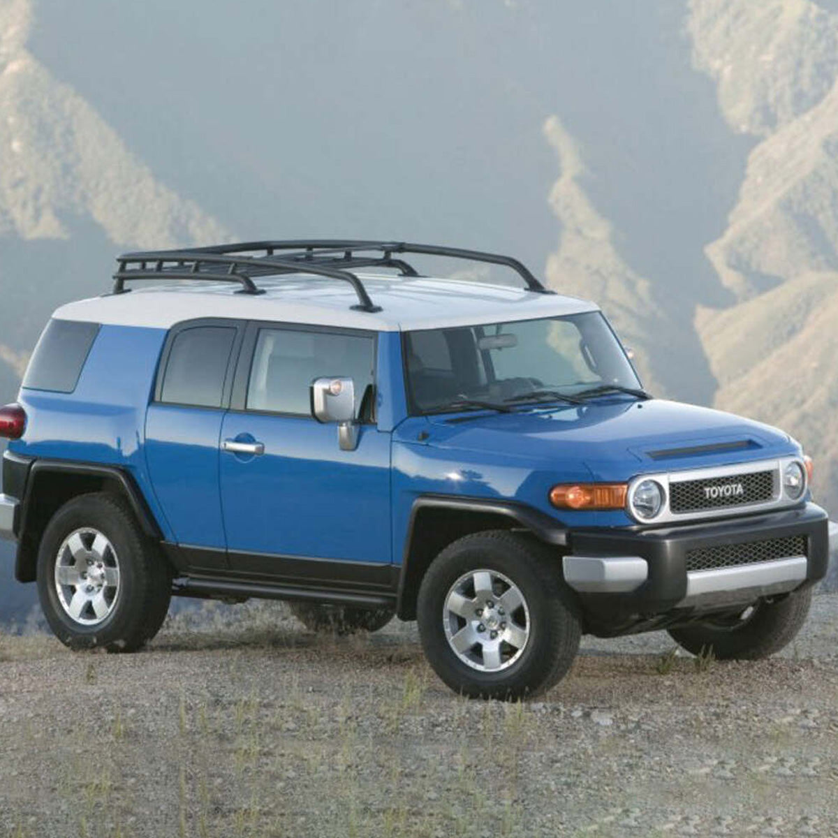 An Old Man Emu upgraded blue Toyota FJ Cruiser with the OME 2 inch Lift Kit for FJ Cruiser (03-09) - Front Shocks Assembly is parked on a hillside, showcasing its superior suspension system and exceptional ground clearance.