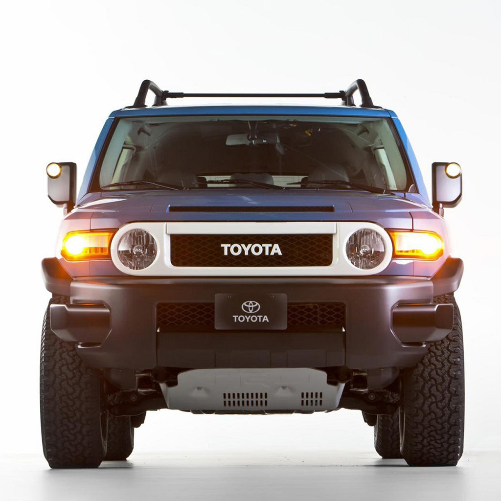 The front end of a blue Toyota FJ Cruiser equipped with an Old Man Emu OME 3 inch Lift Kit for FJ Cruiser (10-ON) - Front Shocks Assembly, offering enhanced ground clearance.
