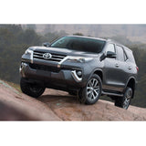 The 2018 Old Man Emu Toyota Fortuner with great ground clearance is driving on a rock.