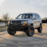 A gray Old Man Emu SUV with outstanding ground clearance is parked on a gravel road, thanks to its reliable OME 2.5 inch Lift Kit for Lexus GX470 (03-09) - Front Shocks Assembly suspension system.