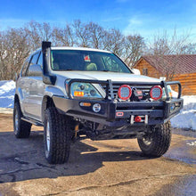 Load image into Gallery viewer, An Old Man Emu-equipped white Lexus GX470 (03-09) SUV parked in the snow near a cabin, showcasing its impressive ground clearance and suspension system with the OME 3 inch Lift Kit - Front Shocks Assembly.