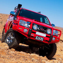 Load image into Gallery viewer, A red Toyota Tacoma with a high ground clearance is driving through a desert, showcasing its reliable Old Man Emu OME 2.5 - 3 inch Lift Kit for Hilux Vigo (05-15) - Front Shocks Assembly suspension system.