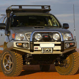 The Old Man Emu 2.5 - 3 inch Essentials Lift Kit Hilux Vigo (05-15), equipped with a reliable suspension system, is parked on a dirt road, showcasing its impressive ground clearance.