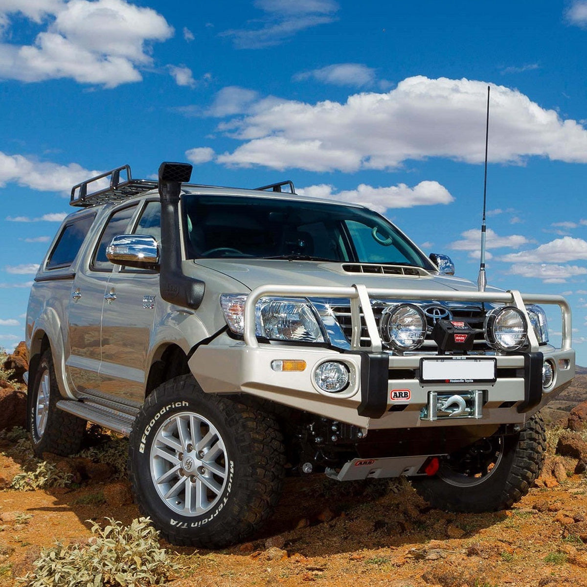An Old Man Emu 2.5 - 3 inch Lift Kit for Hilux Vigo (05-15) parked on a dirt road showcasing its impressive ground clearance.
