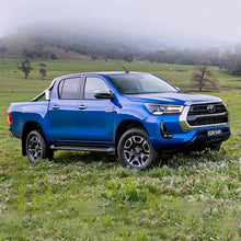 Load image into Gallery viewer, The 2019 Toyota Hilux, equipped with the OME 2.5 - 3 inch Lift Kit for Hilux Revo, Rocco, SR5 (15-22) by Old Man Emu, is parked in a field, showcasing its increased ground clearance.