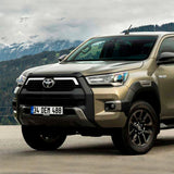 The 2019 Toyota Tacoma, equipped with the OME 2.5 - 3 inch Essentials Lift Kit for Hilux Revo, Rocco, SR5 (15-22) from Old Man Emu, is parked in front of mountains, showcasing its increased ground clearance.