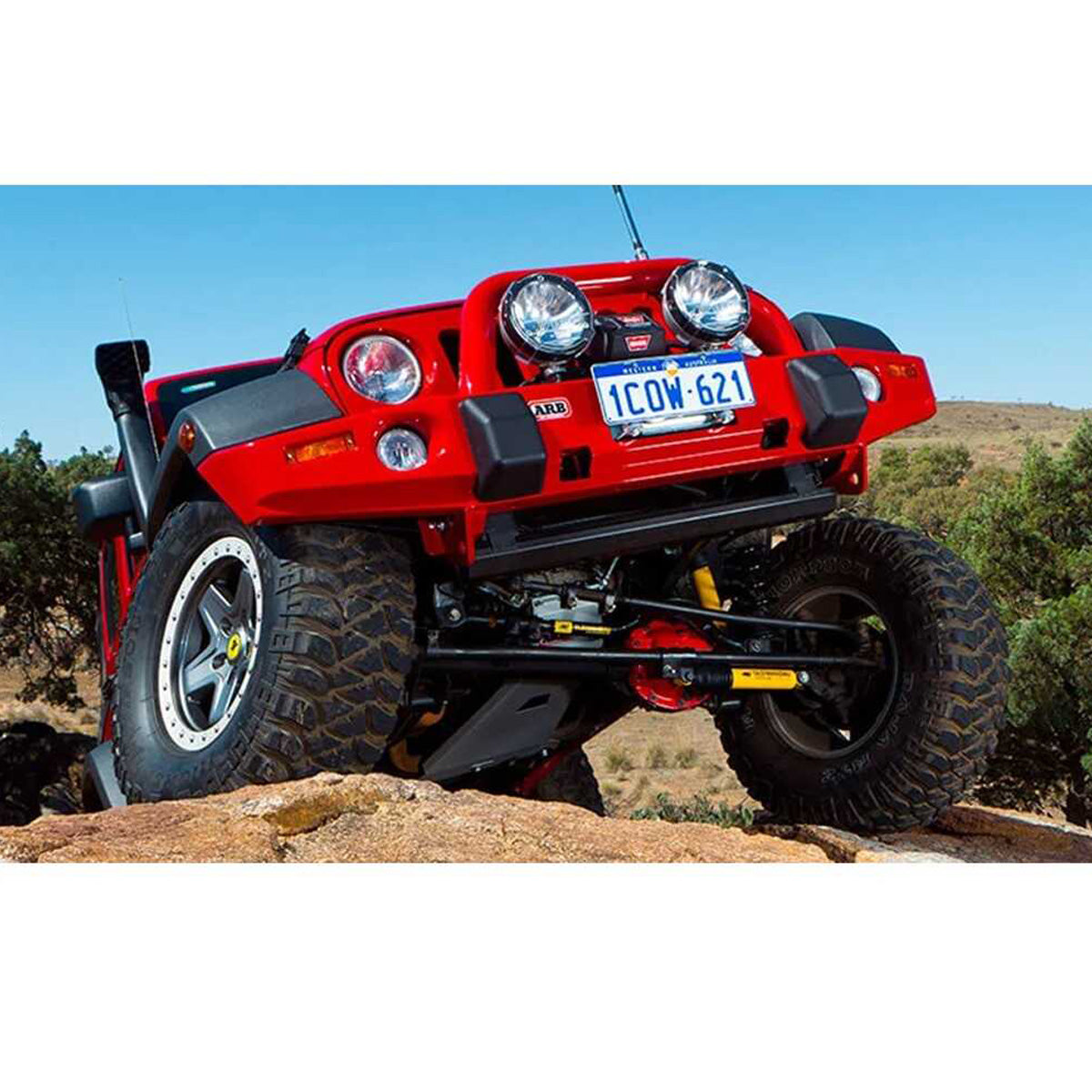 An OME 2 inch Lift Kit for Wrangler JK 4 Door (07-18) equipped red jeep is sitting on top of a rock, showcasing its impressive ground clearance and superior suspension system.