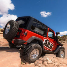 Load image into Gallery viewer, A red Old Man Emu jeep with increased ground clearance is parked on a rock in the desert.