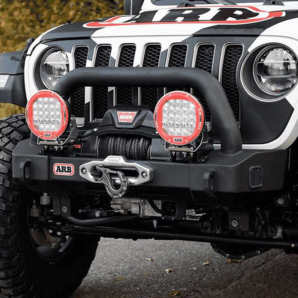 The front end of a jeep with an Old Man Emu OME 2 inch Lift Kit for Jeep Wrangler JL 4 Door (18-23) suspension system and Nitrocharger shocks, providing increased ground clearance.