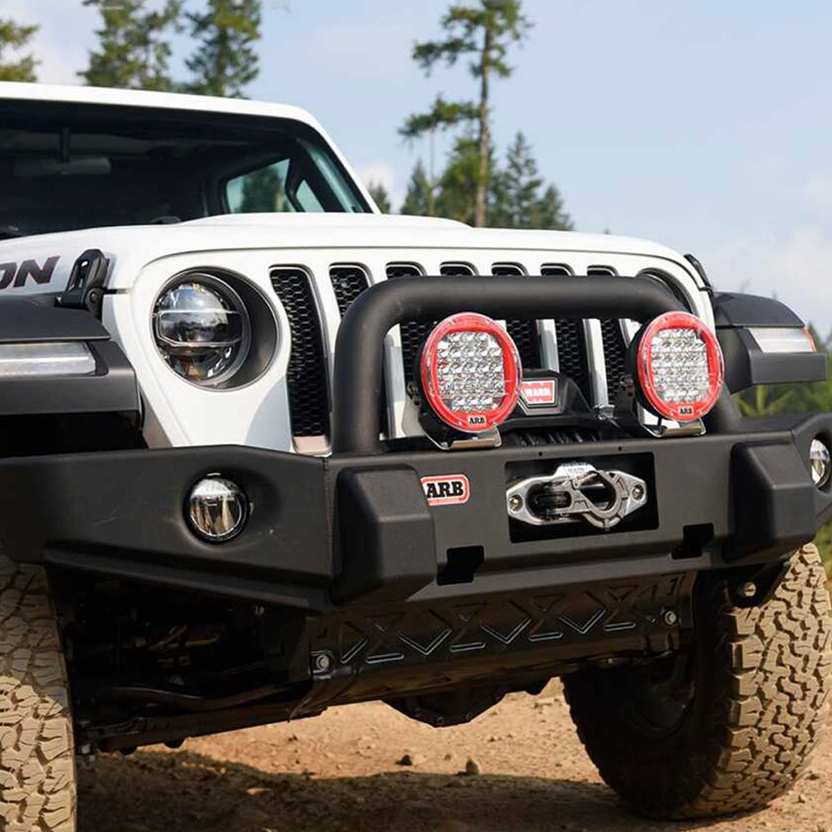 The front bumper of a Jeep Wrangler with an OME 2 inch Lift Kit for Jeep Wrangler JL 4 Door (18-23) by Old Man Emu, providing remarkable ground clearance.