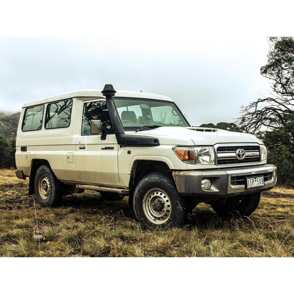 OME Nitro+ 2 inch Lift Kit for Landcruiser 78 Series (10-22) installed on rugged white off-road SUV in grassy terrain
