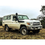 OME Nitro+ 2 inch Lift Kit for Landcruiser 78 Series (10-22) installed on rugged white off-road SUV in grassy terrain