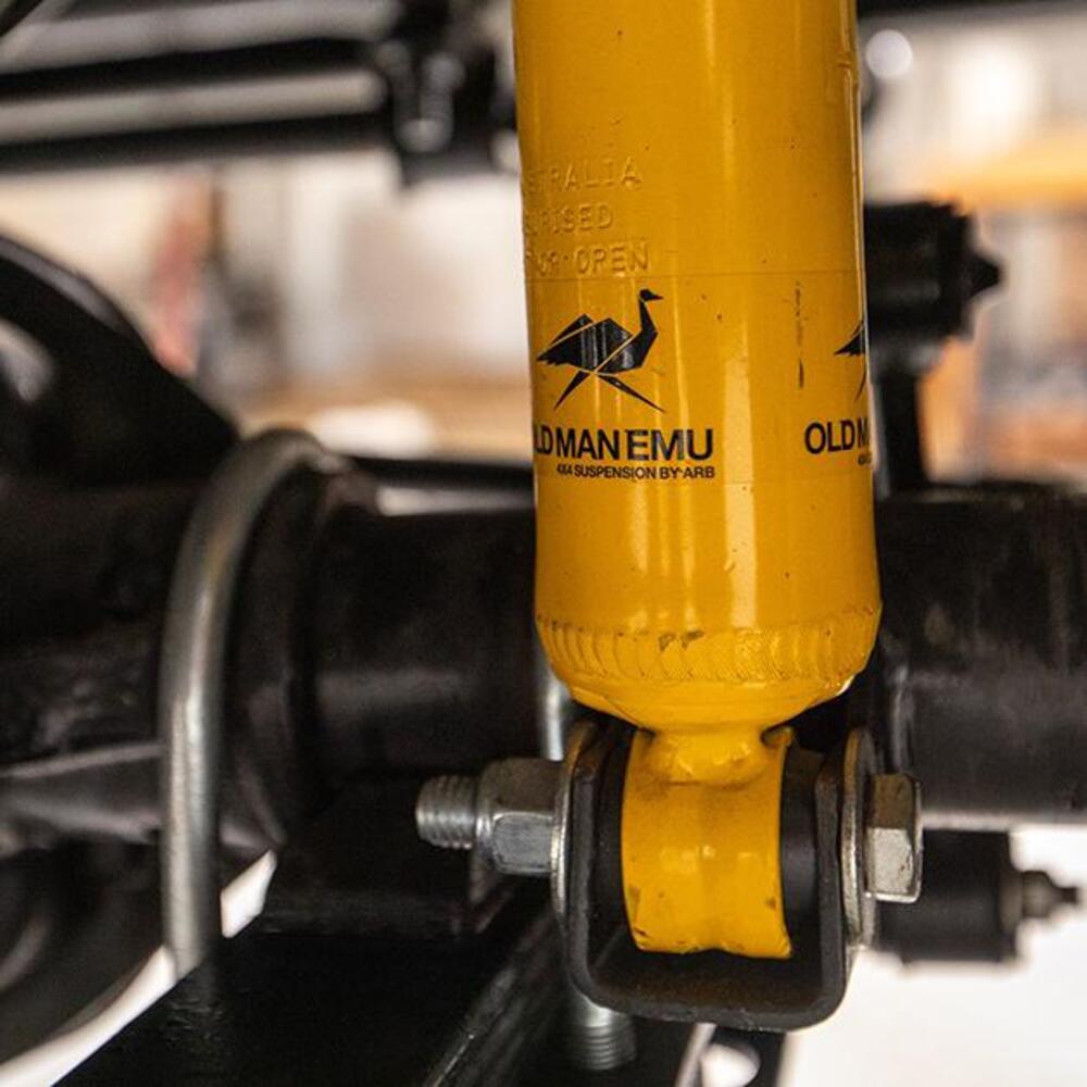 A close up of a yellow Old Man Emu suspension system on a motorcycle.